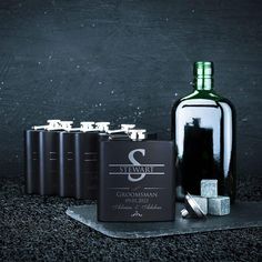 a bottle of wine and six other liquors on a black surface with silver flasks