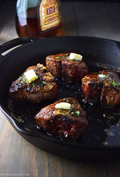 steaks with butter and herbs cooking in a skillet