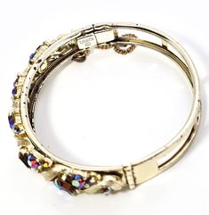 Lisner topaz and aurora borealis mid century signed vintage bangle bracelet. Good used condition with little to no signs of normal wear. No missing stone. Safety chain is still intact. Stamped on the inside of the band Lisner. Bracelet measures 6 and 3/4ths of an inch around and 3/8ths of an inch wide. Vintage Bangle Bracelets, Vintage Bangles, Safety Chain, The Band, Pitcairn Islands, Guinea Bissau, Aurora Borealis, Mozambique, Vintage Signs