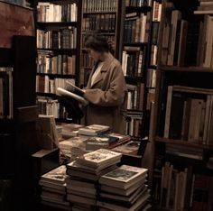 a woman standing in front of a bookshelf filled with lots of book's