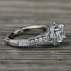 an antique style diamond engagement ring on a wooden table