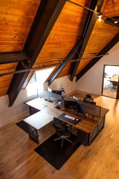 an office with wooden floors and vaulted ceilings