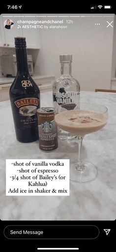 a table topped with two glasses filled with liquid and an empty bottle next to it