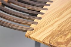 a close up of a wooden bench with curved slats