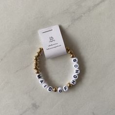 a white and gold beaded bracelet with words on it