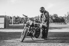 a man standing next to a parked motorcycle