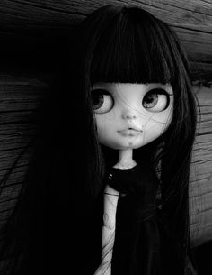 a black and white photo of a doll with long hair