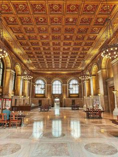 an ornately decorated lobby with chandeliers and tables in the center is shown