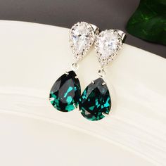 "The color is radiant in this pair of emerald green earrings. The sparkling earrings have a rich shade of emerald green teardrop that is attached to a rhodium plated cubic zirconia pear with sterling silver ear posts. The cubic zirconia earrings are perfect for any special occasion and beautiful enough to be worn by the bride and her bridesmaids. The emerald earrings measure 1 1/4\". Multiples available at checkout with discounted pricing for your bridesmaids gifts. Message me if you don't see t Elegant Green Crystal Earrings For Pierced Ears, Green Crystal Earrings For Pierced Ears, Emerald Drop Crystal Earrings, Green Emerald Drop Crystal Earrings, Green Emerald Drop Earrings, Green Crystal Earrings For May Birthstone Anniversary, Formal Green Dangle Earrings, Green Dangle Earrings For Formal Occasions, Green Drop Earrings For Formal Occasions