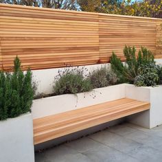 a wooden bench sitting next to two white planters