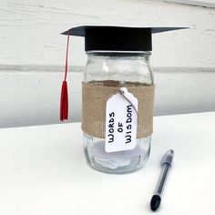 a graduation cap on top of a mason jar with a note pinned to the lid