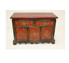 a red and black dresser with ornate carvings on it's sides, against a white background