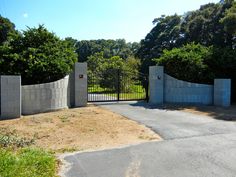 a gated driveway leading into a lush green park