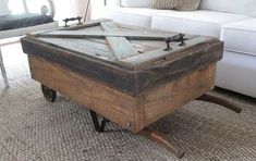 an old wooden box sitting on top of a rug in front of a white couch