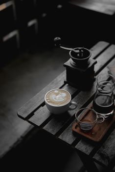 two cups of coffee sit on a wooden table