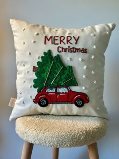 a red car with a christmas tree on it is sitting in front of a white pillow