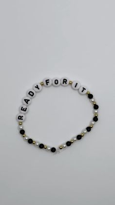 a beaded bracelet with the words readie for it written in white and black beads