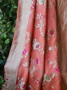 Update! - Zynah covered by LBB - https://lbb.in/bangalore/zynah-designs-handloom-sarees/ This is a pure khaddi georgette banarasi saree in peach color with meenakari and golden zari weave. Saree features a contemporary and spatial floral jaal using vibrant colors and a golden zari in the body of the saree. Golden zari geometrical and symmetrical pattern design is intricately woven in the pallu, the pallu is finished with ultra-fine tassels in multicolor. Florals with leafy designs are compactly Silk Traditional Wear With Floral Embroidery For Celebration, Katan Silk Saree With Intricate Embroidery, Festive Traditional Wear With Floral Embroidery In Brocade, Fitted Banarasi Silk Traditional Wear With Floral Embroidery, Fitted Traditional Wear With Floral Embroidery In Banarasi Silk, Silk Traditional Wear With Intricate Embroidery For Celebrations, Traditional Brocade Wear With Floral Embroidery For Festivals, Elegant Banarasi Silk Traditional Wear With Floral Embroidery, Festive Brocade Traditional Wear With Floral Embroidery