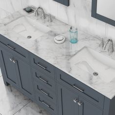 two sinks in a bathroom with marble counter tops