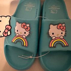 Slip On Sandals/Slides Feature A Cute And Fun Aqua Color With A Cartoon Hello Kitty Theme. The Upper Material Is Made Of Easy-To-Clean Pvc, Making Them A C Practical Choice For Summer. Add Fun And Style To Your Summer Wardrobe. Light Blue Synthetic Slip-on Slides, Light Blue Synthetic Slides With Round Toe, Cute Slip-on Slides For Spring, Cute Spring Slip-on Slides, Cute Blue Round Toe Sandals, Playful Blue Adjustable Sandals, Playful Adjustable Blue Sandals, Playful Synthetic Slides For Spring, Spring Playful Synthetic Slides