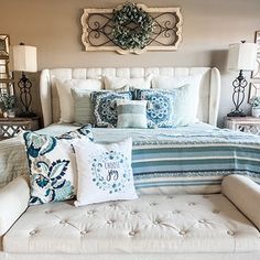 a bed with blue and white pillows on it