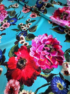 a blue floral print fabric with red, pink and purple flowers on it's side