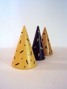 three party hats with sprinkles on them are lined up against a white background