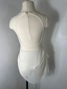 a mannequin with a white dress on display