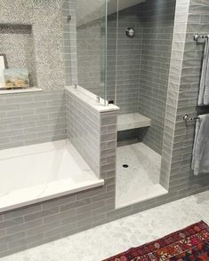 a white bath tub sitting next to a walk in shower