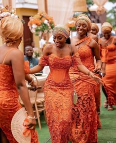 two women in orange dresses are dancing together