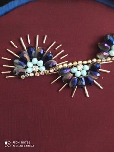 a close up of a necklace on a woman's neck with blue beads and gold spikes