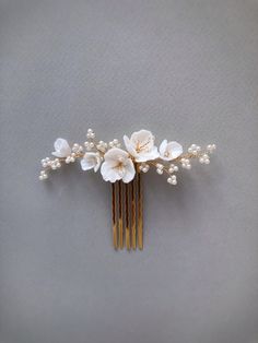 a hair comb with flowers and pearls on it