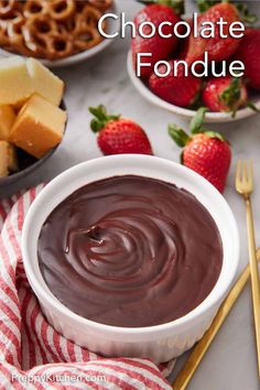 chocolate fondue in a bowl with strawberries and pretzels on the side