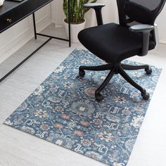 an office chair sitting on top of a rug in front of a desk