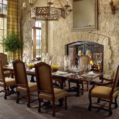 a dining room table with chairs and a chandelier hanging from it's ceiling