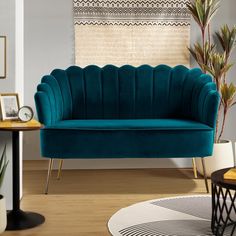 a blue couch sitting on top of a hard wood floor next to a potted plant