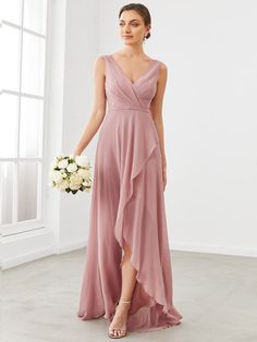 a bridesmaid in a pink dress holding a white bouquet and standing next to a window