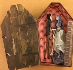 an open box with a doll and skeleton in it