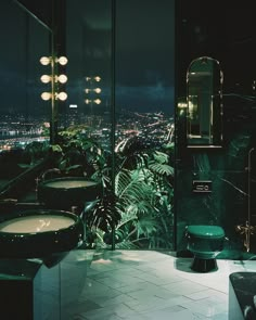 a bathroom with two sinks and a bathtub in it's center, surrounded by greenery