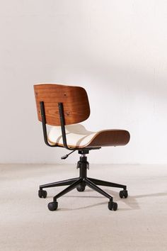 an office chair sitting on top of a white floor next to a wooden desk lamp