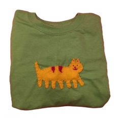 a green t - shirt with a yellow cat embroidered on it