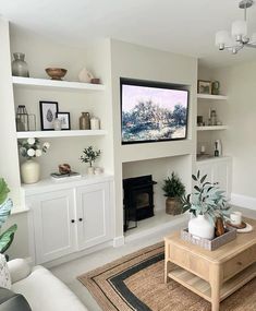 a living room filled with furniture and a flat screen tv mounted on the wall above a fireplace