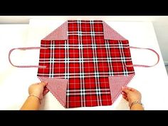 someone is making a red and white plaid bag