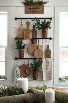 a kitchen wall with cutting boards and potted plants hanging from it's hooks