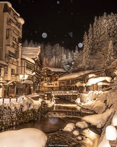 a snow covered town at night with lights on