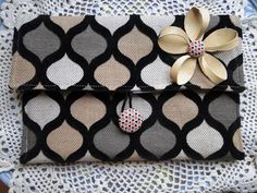 a black and white purse with a flower on the front, sitting on top of a lace doily