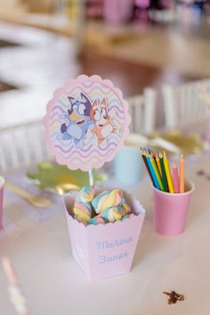 a table topped with cups filled with candy