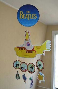 a yellow submarine clock hanging from the side of a wall next to a window in a child's room