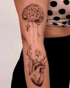 a woman with a tattoo on her arm has a heart and brain attached to it