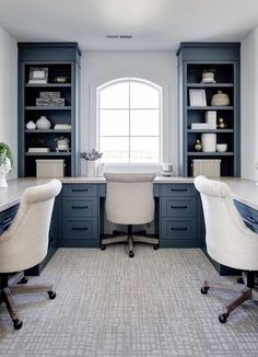 two white chairs sitting in front of a desk